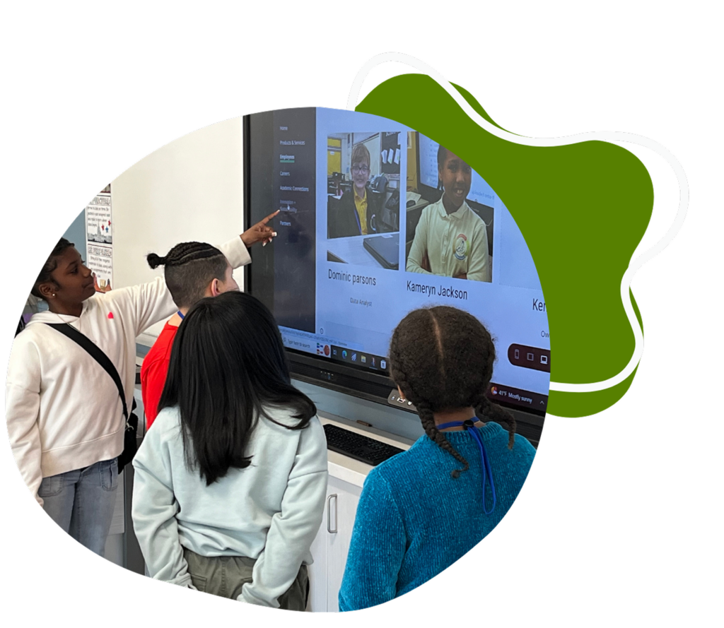 Photo of students interacting with a large touchscreen display.